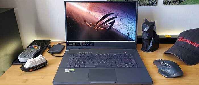 لپ تاپ ایسوس ROG Zephyrus M15 GU502LW روی میز در کنار ماوس و گیم پد